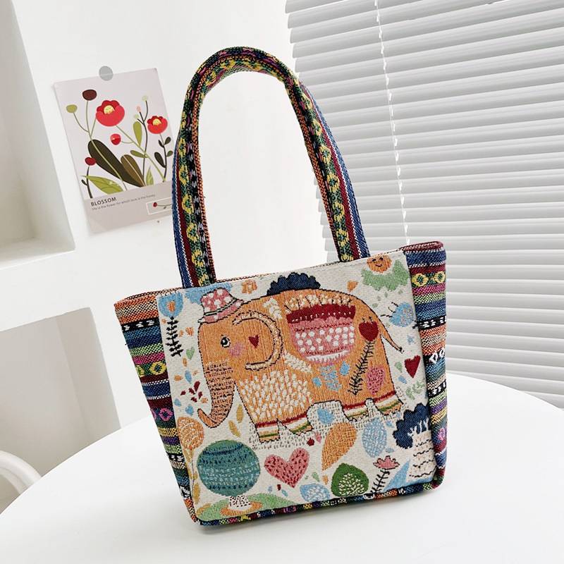 Cream tote bag with an embroidered elephant wearing a hat